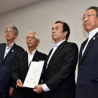 検討委の猪狩貢委員長（左から２人目）が「ふたばグランドデザイン」の報告書を伊沢史朗・双葉地方町村会長（同３人目）に手渡した＝福島県富岡町小浜の双葉地方町村会館で