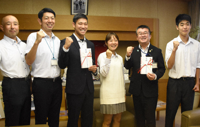 松沼花音・七高祭実行委員長(中央)から寄付金を贈呈された小久保寛太選手(左から2人目)=埼玉県本庄市役所で
