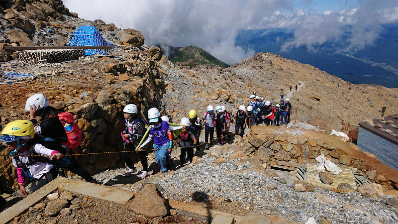 木曽町側の頂上の剣ケ峰に着いた三岳小児童=長野県木曽町の御嶽山で2019年9月6日午後1時19分、小川直樹撮影
