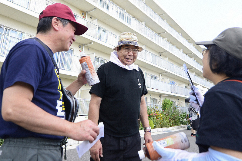 夏祭りの参加者と談笑する鶴島一浩さん(中央)=福島県南相馬市原町区の南町団地で2019年8月25日、渡部直樹撮影