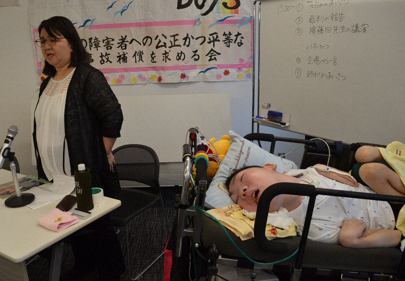 ストレッチャーで集会に参加した河村啓太さん(右)と制度改善を訴える母和美さん