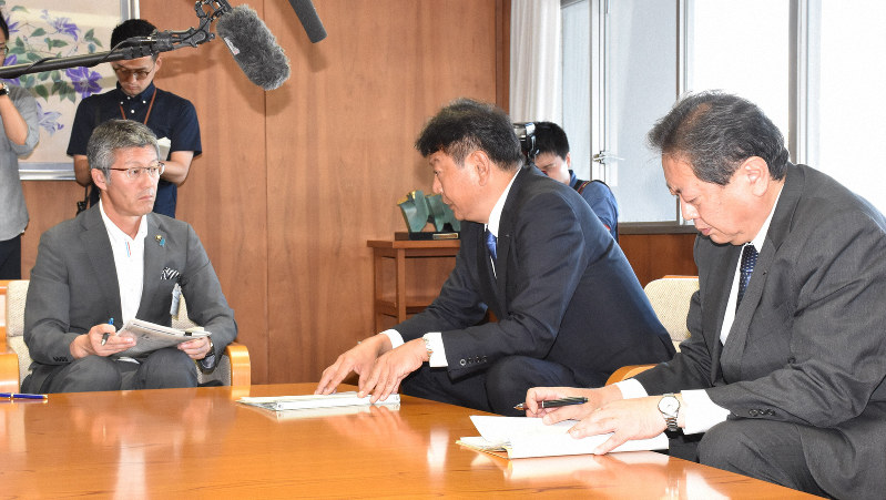 新潟県柏崎市の桜井雅浩市長(左)に説明する東電の小早川智明社長(中央)=新潟県柏崎市の柏崎市役所で8月26日、井口彩撮影