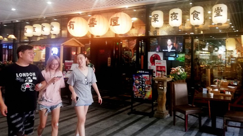 「深夜食堂」を前面に打ち出した日本料理店。店頭では日本版の映画が流れていた=上海市内で8月21日、赤間清広撮影