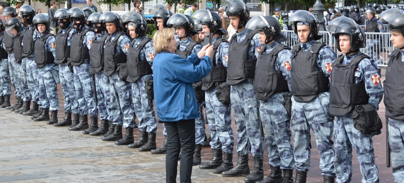 モスクワ市議選を巡るデモでは、一人の女性が抗議の意味を込め、警官隊の前まで進み写真を撮っていた=モスクワで2019年8月3日、大前仁撮影