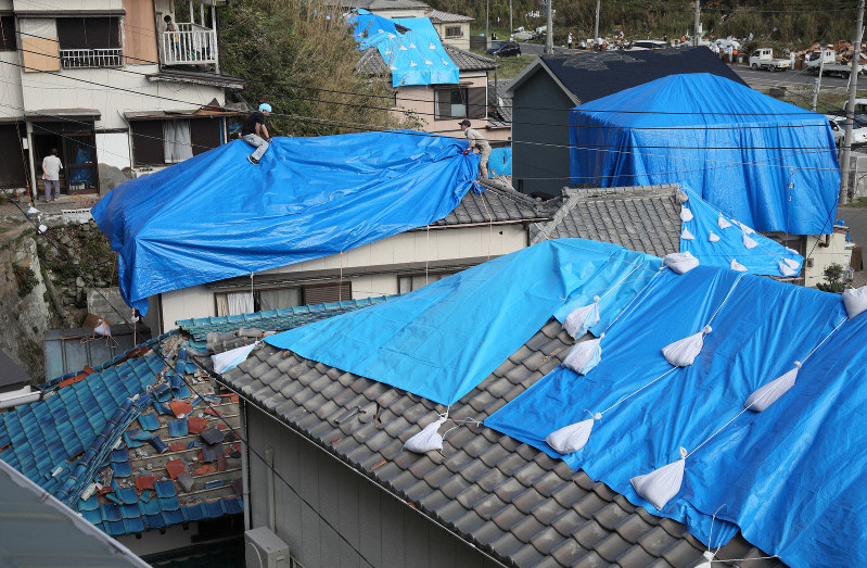雨に備えて、台風で被害を受けた屋根にブルーシートをかける人たち=千葉県鋸南町で2019年9月15日午後3時13分、佐々木順一撮影