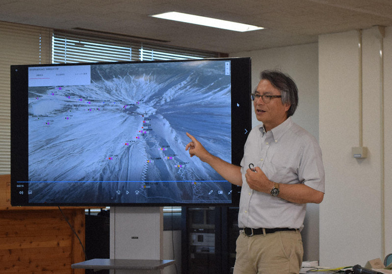 ビーコンを使った実験の仕組みを説明する富士山チャレンジプラットフォームの田中義朗代表理事=長野県庁で