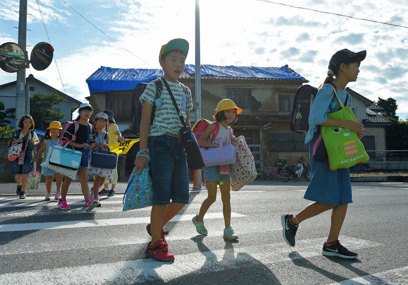 小学校が再開し、登校する児童たち。通学路わきの家屋には雨よけのブルーシートが張られている=千葉県南房総市で2019年9月17日午前7時41分、手塚耕一郎撮影