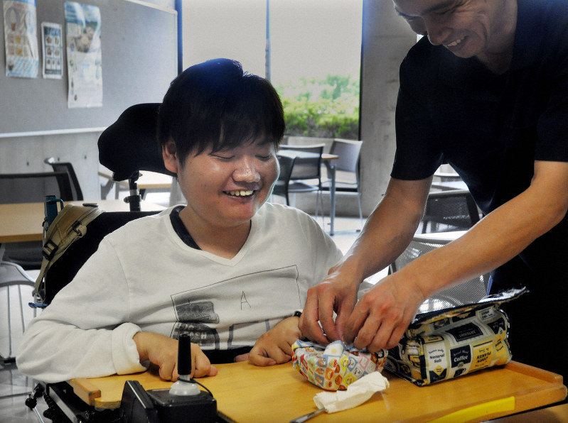 学内のフリースペースで昼食の準備をするヘルパーと田子森敦史さん=福岡市東区の福岡工業大で2019年9月3日午後0時21分、杣谷健太撮影