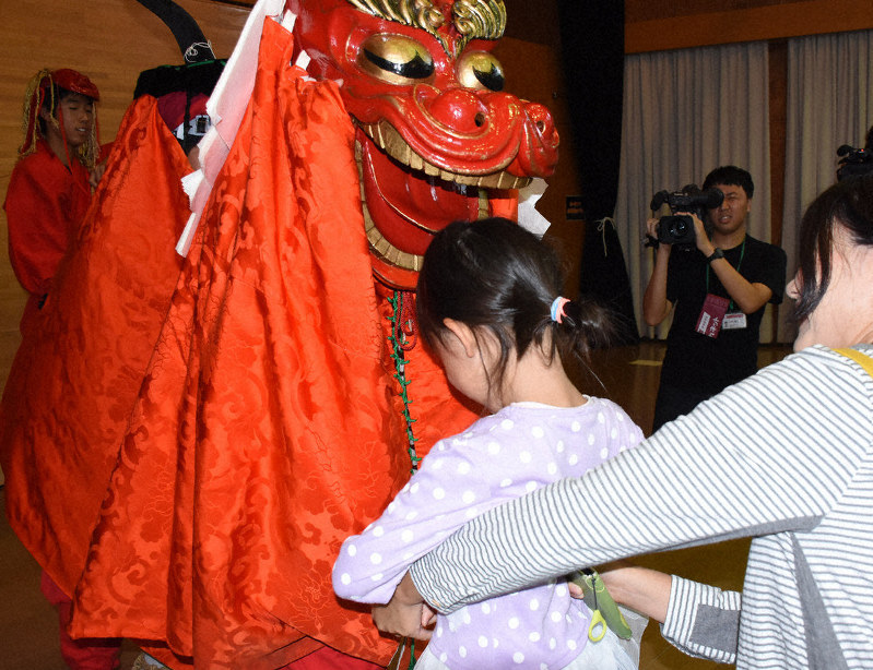 麒麟獅子に頭をかんでもらい、無病息災を願う子供たち=鳥取市浜坂で、阿部絢美撮影