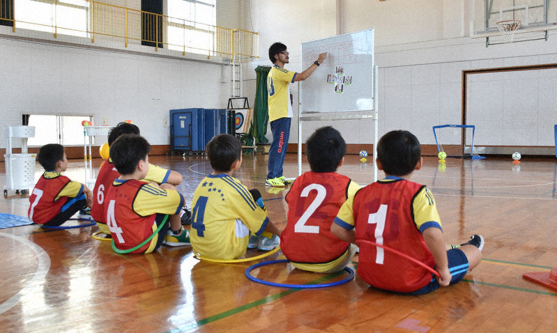 座る場所を分かりやすく示したフラフープの輪の中で宮本さんの説明を聞く子供たち=高松市内で、山口桂子撮影
