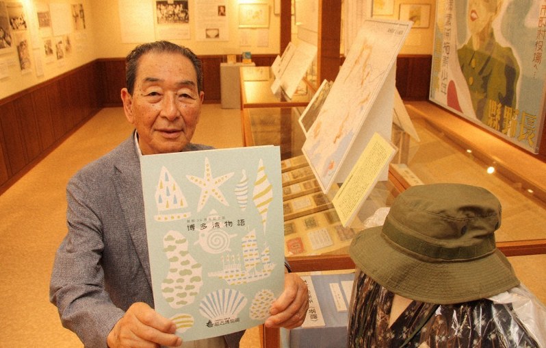 能古博物館の開館30周年記念誌「博多湾物語」を手にする副館長の西牟田耕治さん=福岡市西区で、飯田憲撮影