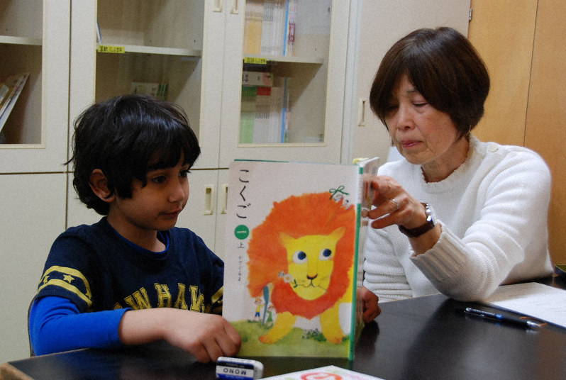 日本語指導員の阿久津さん(右)とひらがなの勉強をするパキスタンから来た男児=新潟県新発田市で5月15日、堀智行撮影