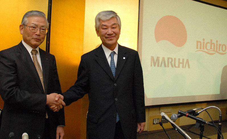 統合を発表し、握手する田中(左)と五十嵐=2006年12月