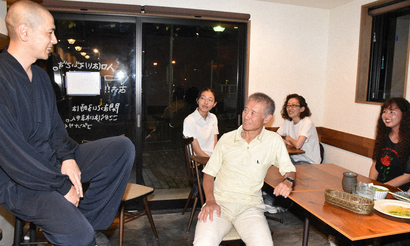 濱田龍一さん(左)の法話を楽しむ人々=金沢市彦三町1で濱田龍一さん(左)の法話を楽しむ人々=金沢市彦三町1の小橋カフェOTABAで、日向梓撮影
