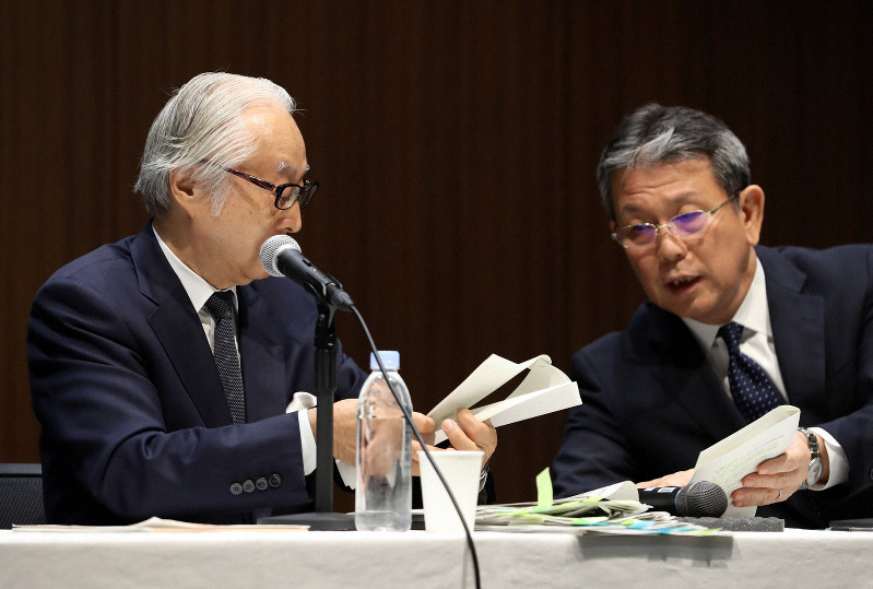 記者会見中、かんぽ生命保険の植平光彦社長(右)と言葉を交わす日本郵政の長門正貢社長=2019年9月30日、小川昌宏撮影