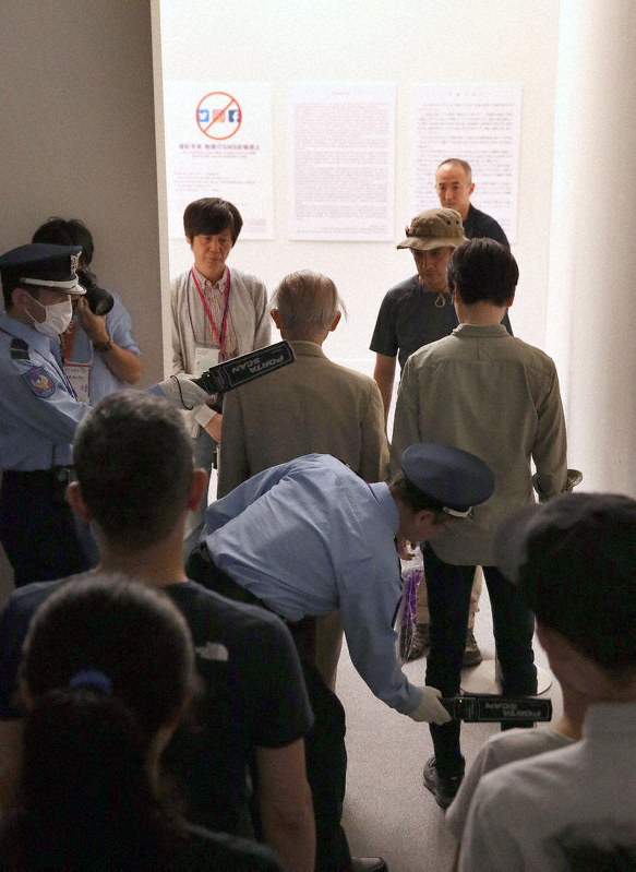 展示中止となっていた企画展「表現の不自由展・その後」の入場前に金属探知機でチェックを受ける人たち=名古屋市東区の愛知芸術文化センターで8日(代表撮影)
