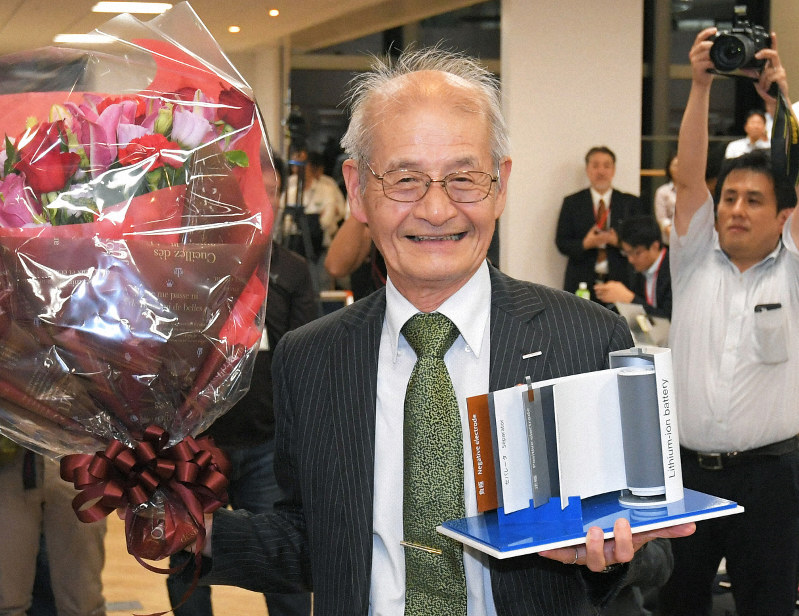 リチウムイオン電池の模型と花束を手に笑顔を見せる吉野彰・旭化成名誉フェロー=東京都千代田区の旭化成東京本社で2019年10月9日午後8時21分、手塚耕一郎撮影