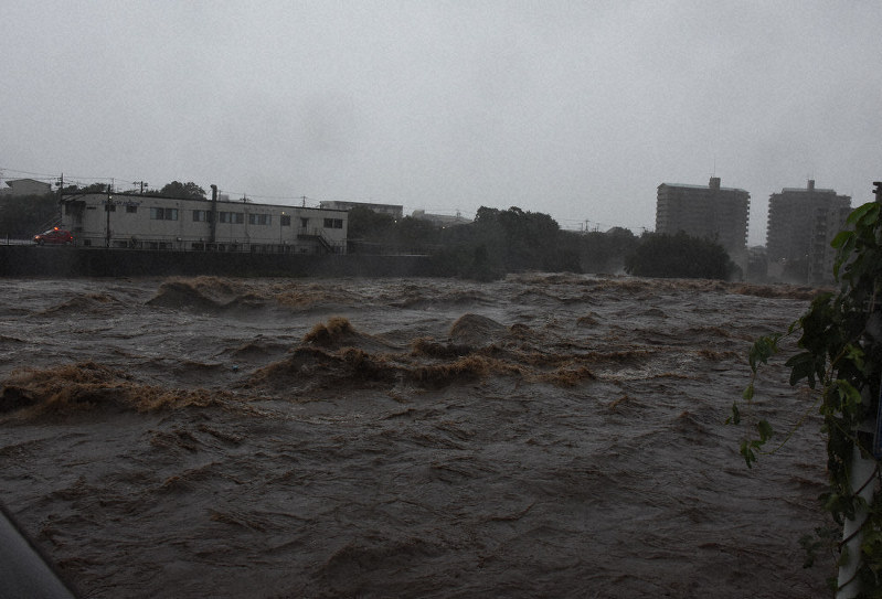 真っ黒な水が濁流となって流れる黄瀬川=静岡県長泉町下土狩の鮎壺の滝で12日午後3時半