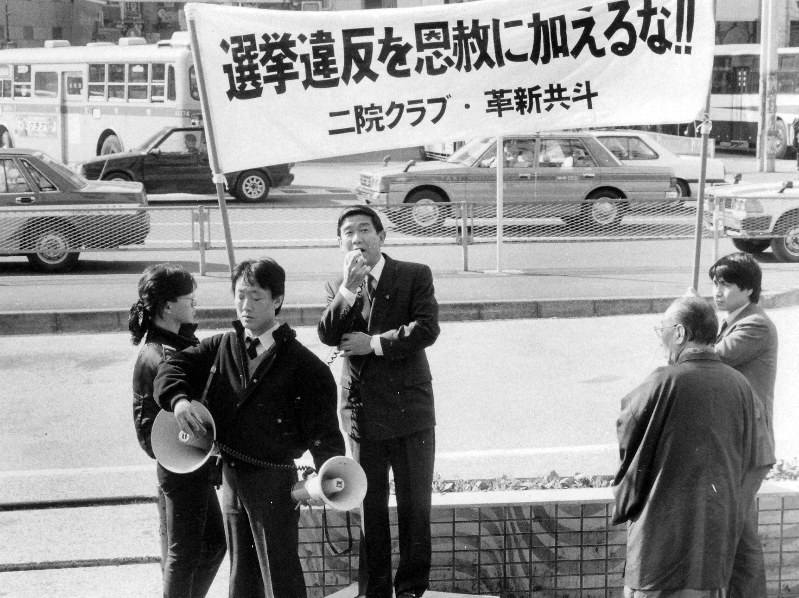 “大喪恩赦”で市民に訴える青島幸男さん(中央)=東京・渋谷駅前広場で1989年2月6日