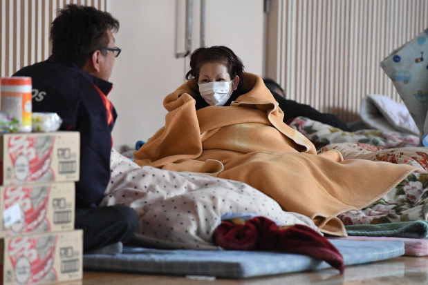 2016年の熊本地震で被災し、避難所で毛布や布団で寒さをしのぐ人たち=熊本県南阿蘇村で同年4月19日