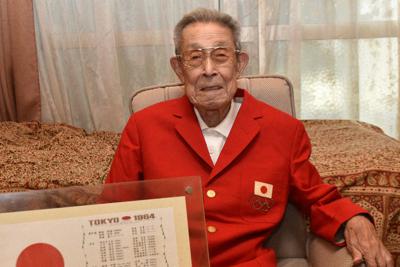１９６４年東京五輪の日本選手団の赤いジャケットを着て、２０２０年東京五輪への期待を語る石黒昇さん＝埼玉県戸田市の自宅で、小林悠太撮影