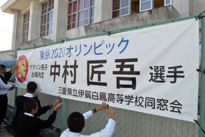フェンスに中村匠吾選手を応援する横断幕を取り付ける生徒ら＝三重県伊賀市の伊賀白鳳高で、大西康裕撮影