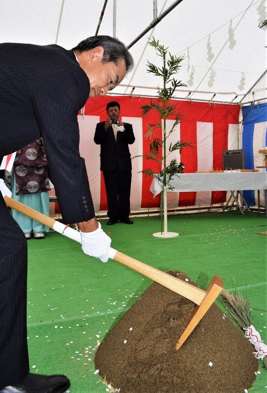 施設の無事完成などを願ってくわ入れする高橋広樹・県企業管理者=山形県酒田市で