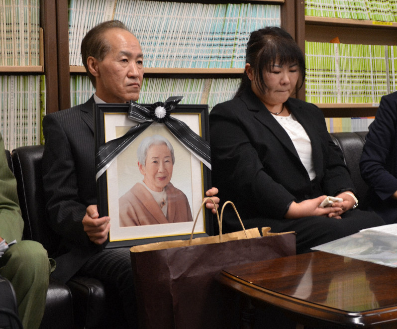 死亡した女性の写真を手に提訴理由を語る女性の長男(左)と長女=名古屋市中区で2019年10月18日午後1時51分、川瀬慎一朗撮影