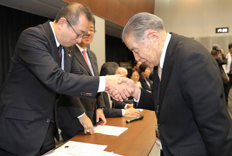 ハンセン病元患者家族に補償する法案の骨子がまとまり、超党派議員懇談会事務局長の津島淳衆院議員(左)と握手する林力原告団長=東京都千代田区で2019年10月24日午後5時27分、宮武祐希撮影