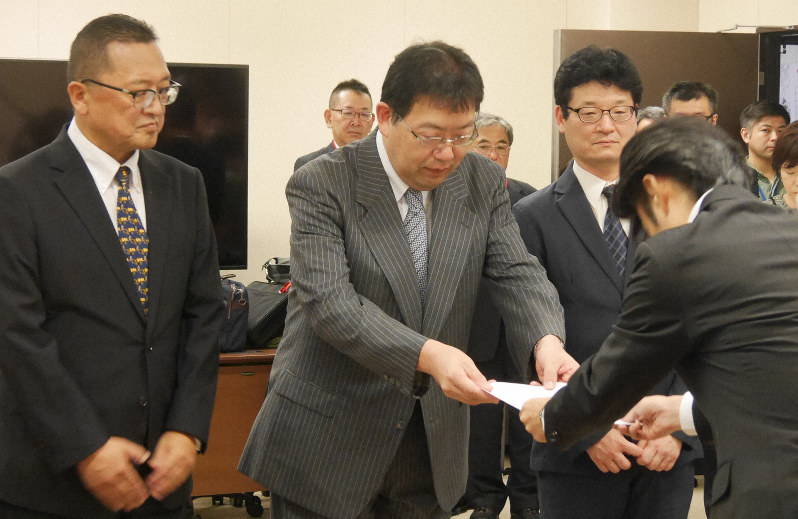 「受験生の不安が払拭されていない」として、文科省の担当者に英語民間試験の実施の延期を求める要望書を手渡す全国高校長協会の萩原聡会長(写真中央)=東京都千代田区で2019年9月10日午後3時59分、水戸健一撮影
