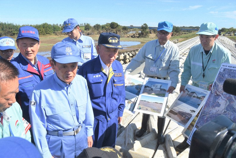 台風19号の影響で堤防が決壊した埼玉県川越市の越辺川の現場で、被害や復旧状況の説明を受ける菅義偉官房長官(手前左から2人目)=2019年10月26日午前11時、秋山信一撮影