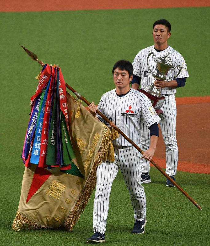 ダイヤモンド旗を返還する三菱重工名古屋の安田亮太主将(手前)=京セラドーム大阪で