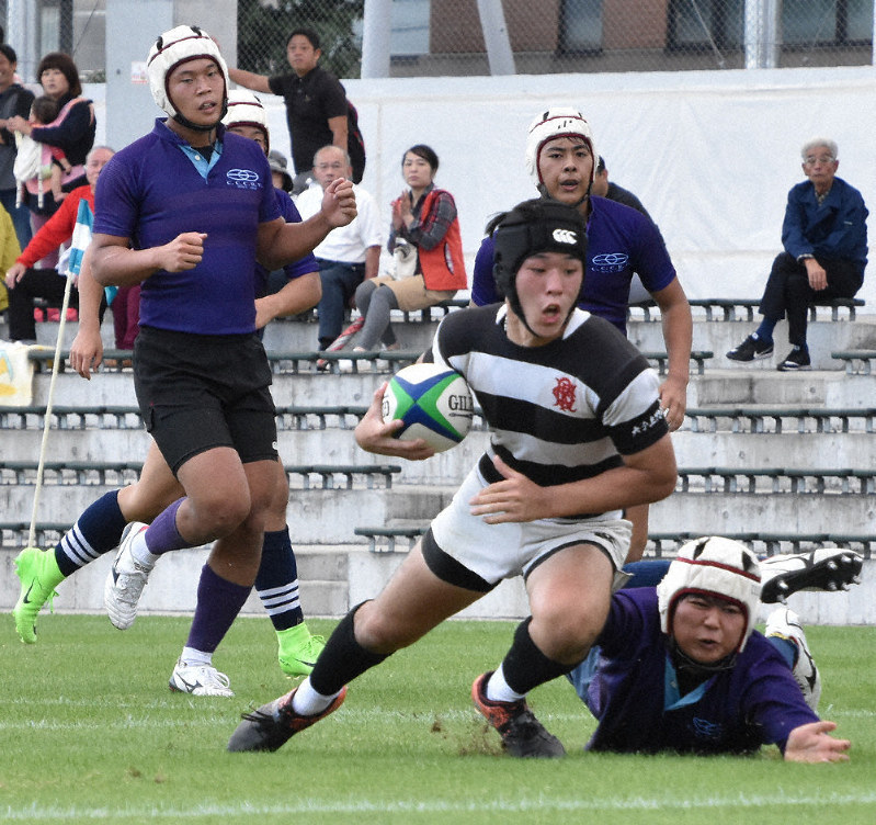 相手を振り切る大分上野丘の松田瑞樹選手(中央)。この後トライを決める