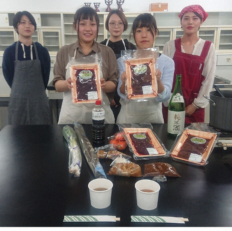 静岡県浜松市天竜区春野で仕入れた鹿肉を持ち、学園祭で販売する「春野の鹿鍋」をPRする静岡文化芸術大の伝承文学ゼミの学生たち=同市中区の同大で
