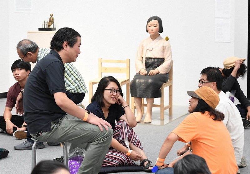 再開された「表現の不自由展・その後」で、「平和の少女像」を前にディスカッションする参加者=名古屋市東区で11日(代表撮影)