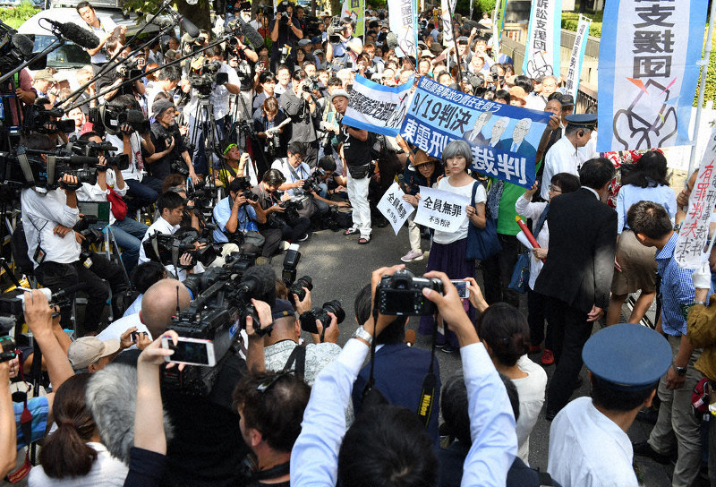 「全員無罪 不当判決」と書かれた紙を掲げる福島原発告訴団の関係者=東京都千代田区の東京地裁前で9月19日午後1時23分、宮間俊樹撮影