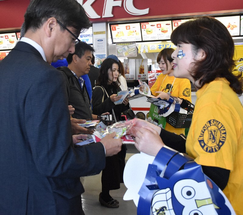試合前にオリジナルグッズなどを受け取る日本新薬のファンクラブ会員(左)=京セラドーム大阪で2019年10月30日午前9時40分、添島香苗撮影