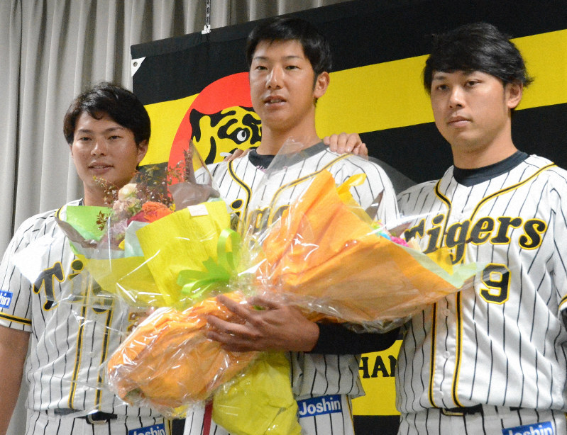 引退記者会見で北條史也選手(左)と高山俊選手(右)から花束を受け取った横田慎太郎さん=兵庫県西宮市の球団事務所で2019年9月22日午後0時17分、藤田健志撮影