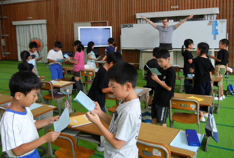 サンドビグさん(奥)から英語で算数を学ぶ児童=愛知県豊橋市立八町小で