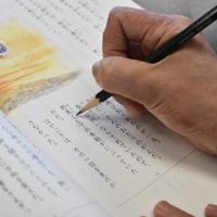 フィリピン人の男児の教科書に振り仮名をつける特別支援学級の女性教諭。外国籍の子どもの指導は教諭によって差が出る=関東地方の小学校で、鈴木敦子撮影