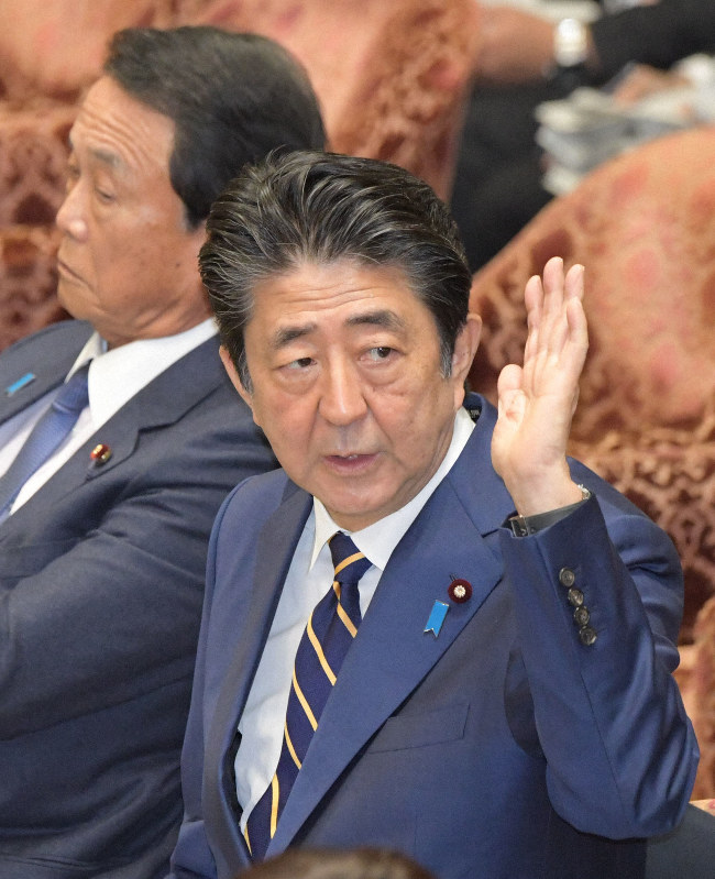 衆院予算委員会の集中審議で2人の閣僚の相次ぐ辞任について答弁のため挙手する安倍晋三首相(右)=国会内で2019年11月6日午後1時6分、川田雅浩撮影