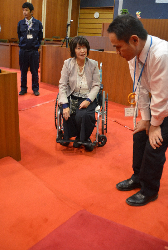議場内の段差解消について説明を受ける車椅子の林さん=千葉県大網白里市役所で