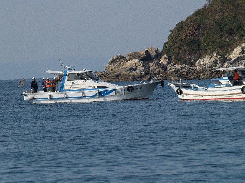 海上ボーリング調査の予定海域で9日午後、作業船(左)に準備作業に入らないように呼び掛ける反対派の船