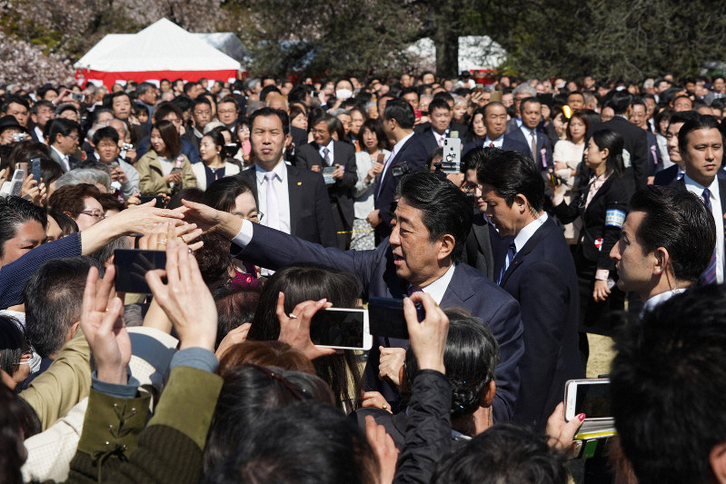 今年の「桜を見る会」で来場者と握手をして回る安倍晋三首相(右)=東京都新宿区の新宿御苑で2019年4月13日(代表撮影)