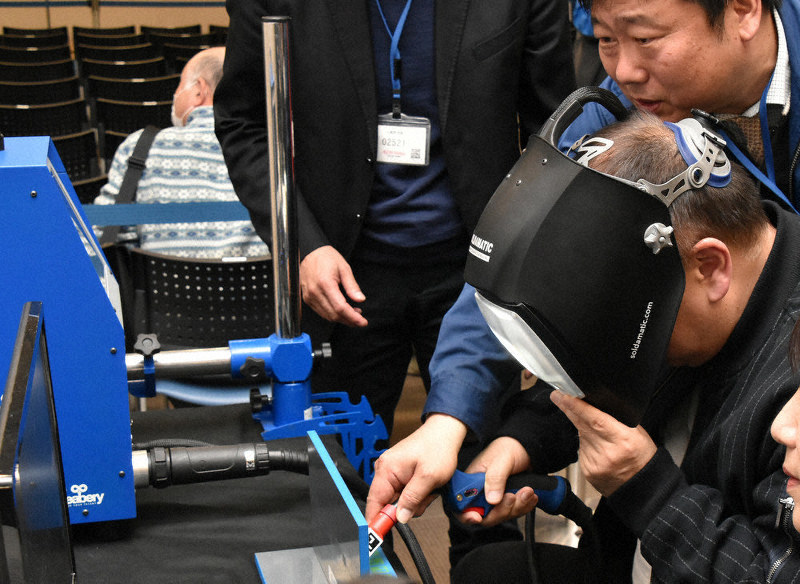 AR技術を利用した溶接技能訓練を体験する参加者(手前)ら=草津市新浜町のイオンモール草津で、成松秋穂撮影
