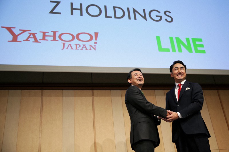 経営統合についての記者会見で笑顔で記念撮影に応じるZホールディングスの川辺健太郎社長(左)とLINEの出沢剛社長=東京都港区で2019年11月18日午後5時42分、吉田航太撮影