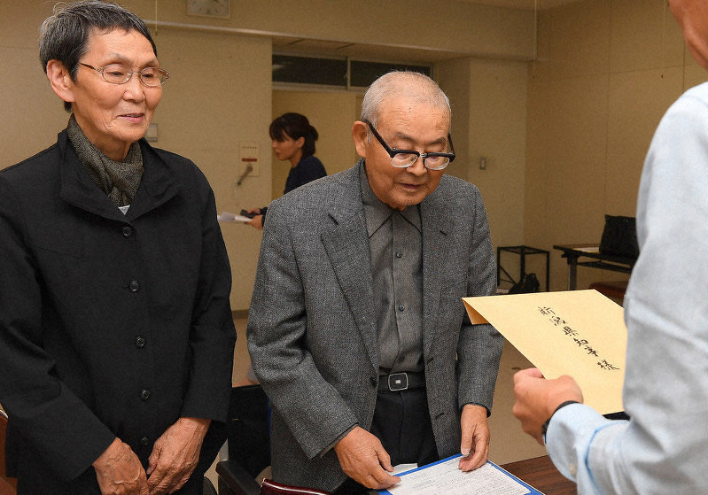 過労死防止対策の説明を新潟県知事に求める要請書を、県職員に手渡す大橋義則さん(右)と妻の喜代子さん=新潟市中央区の県庁で2019年9月、北山夏帆撮影