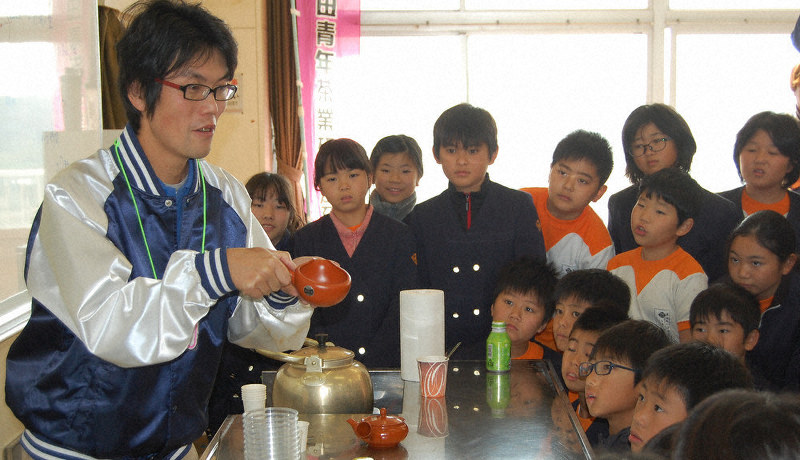 湯冷ましを手に持ち、おいしいお茶のいれ方を子供たちに伝える磐田青年茶業研究会のメンバー=静岡県磐田市高見丘の豊田東小で