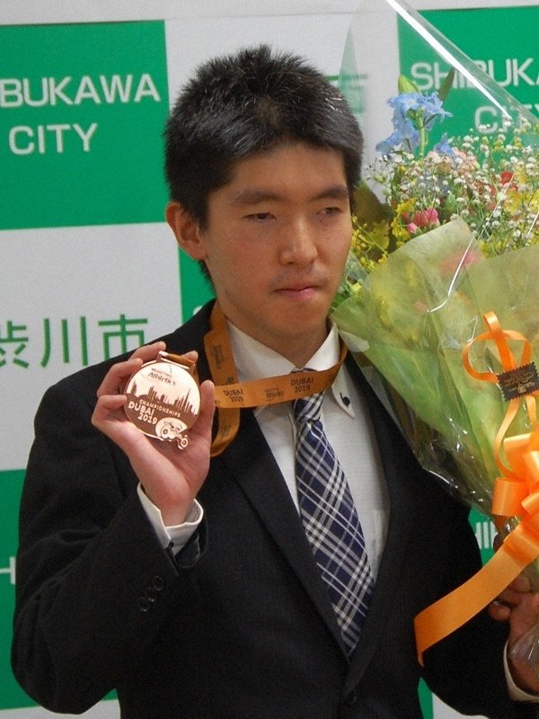 お祝いの花束を受け取った唐沢剣也選手=群馬県渋川市役所で