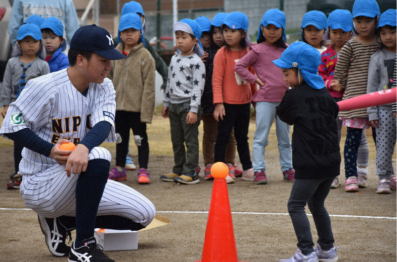 日本通運の内海大寿選手(左)からボールの打ち方を教わる園児=さいたま市緑区の原山保育園で